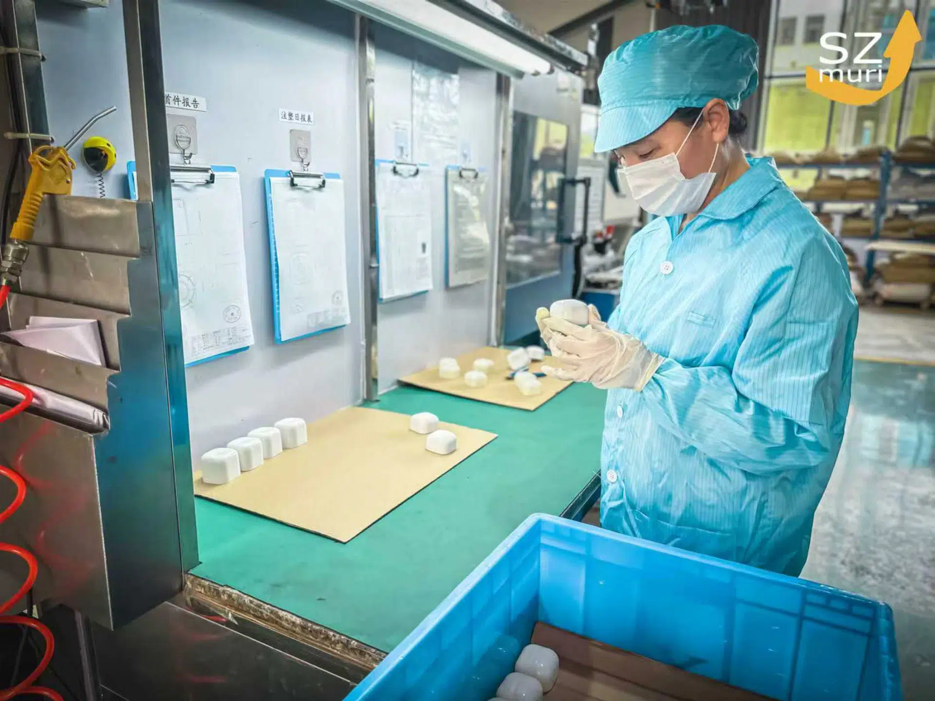 Eine Person in blauer Arbeitskleidung prüft konzentriert weiße Bauteile unter Licht