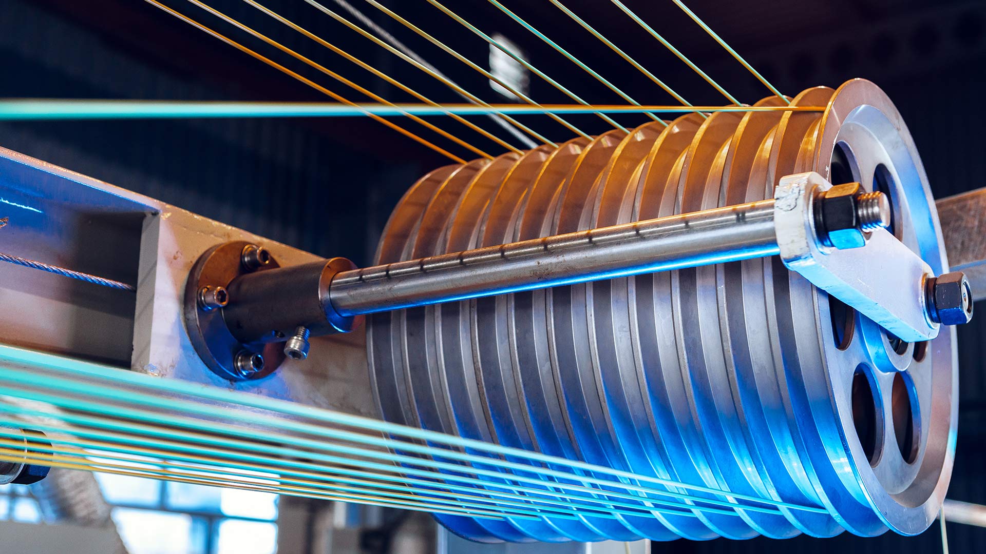 Ein silbernes Metallrad mit vielen Rillen und bunten gespannten Fäden